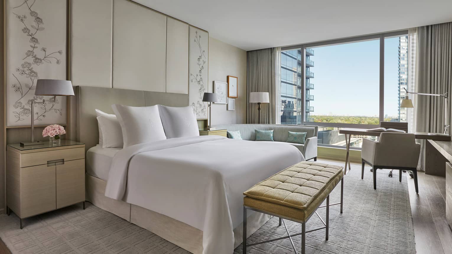Hotel room with cream, white and light grey colouring, king bed, floor-to-ceiling windows