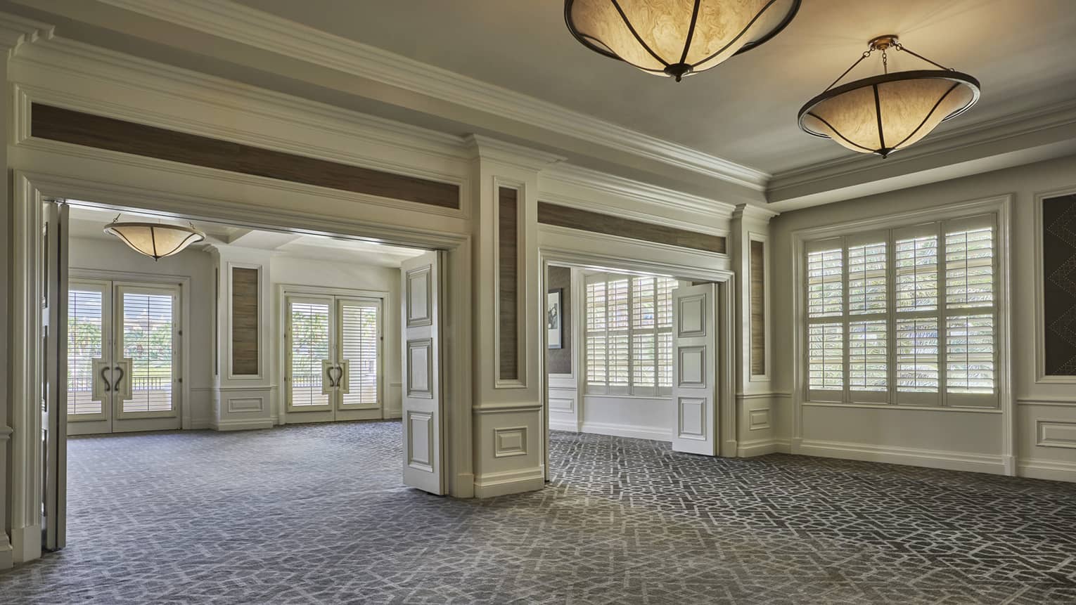 Mesquite event space, open carpeted room with sunny windows, large ceiling lights 
