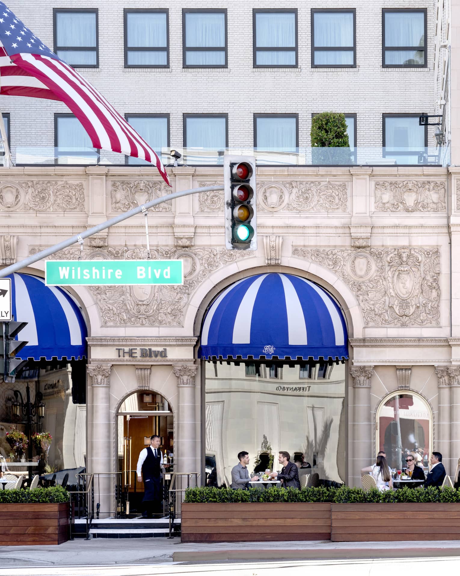 A patio where people are eating outside of a stone building.