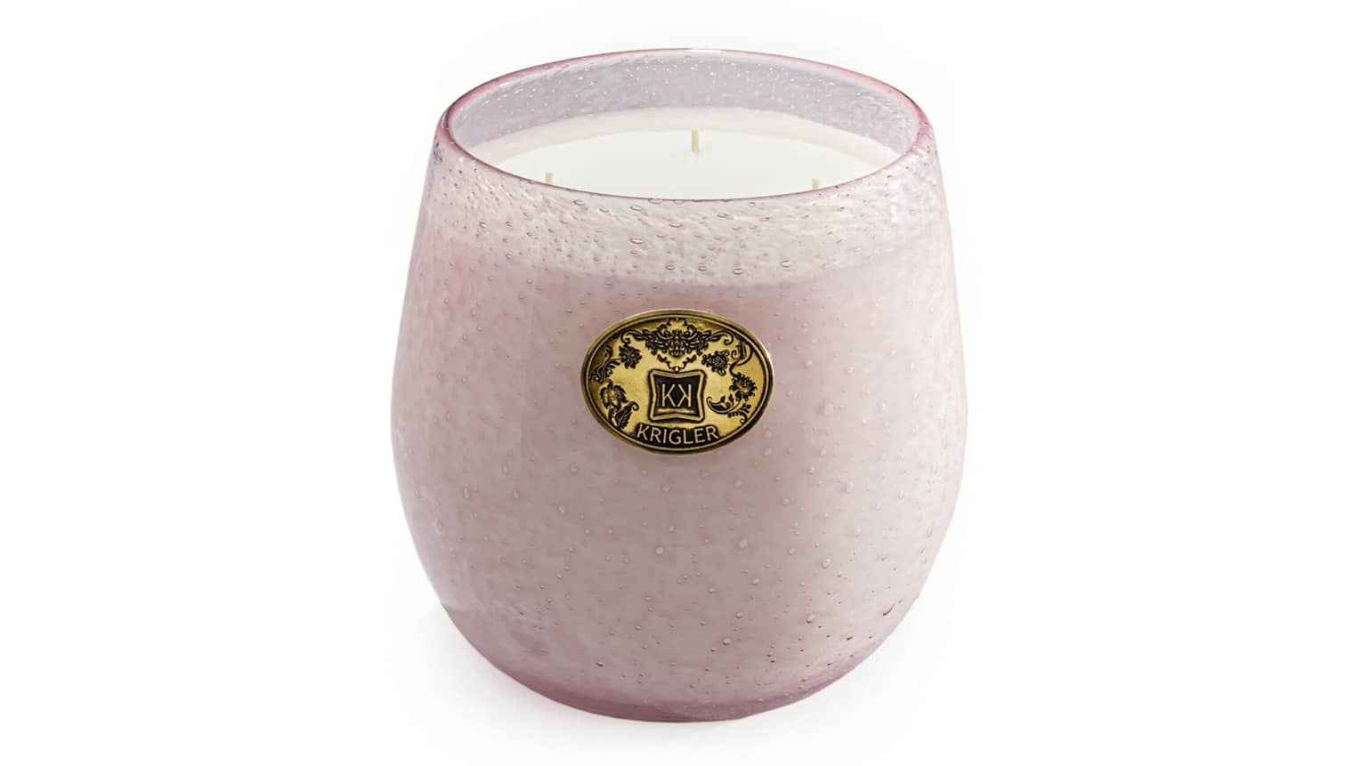 A pale pink glass candle with a gold embossed "Krigler" emblem on a white background