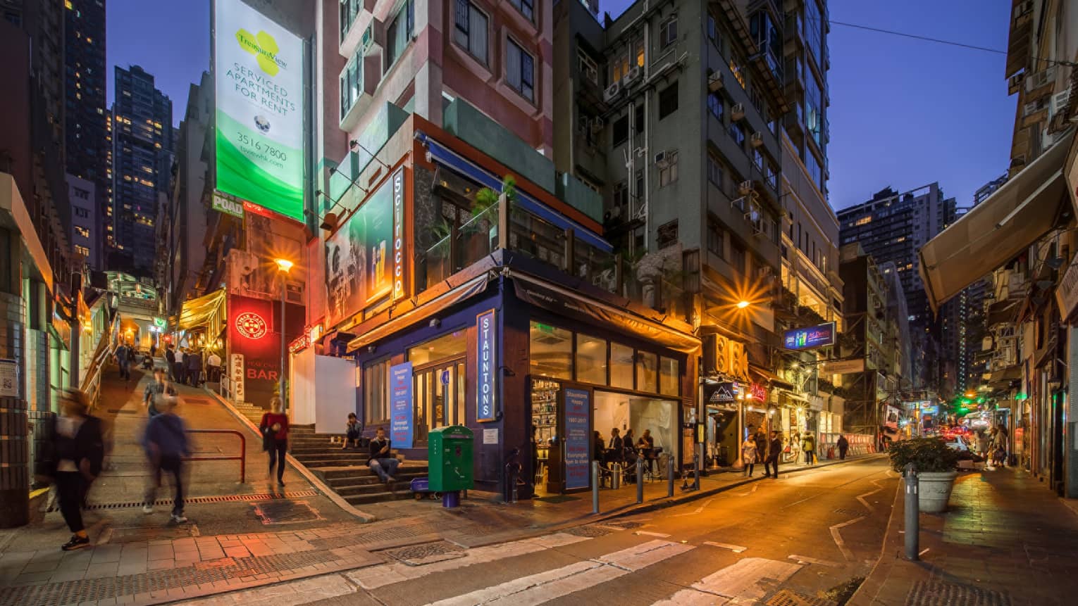 A corner building on a city street, illuminated at night