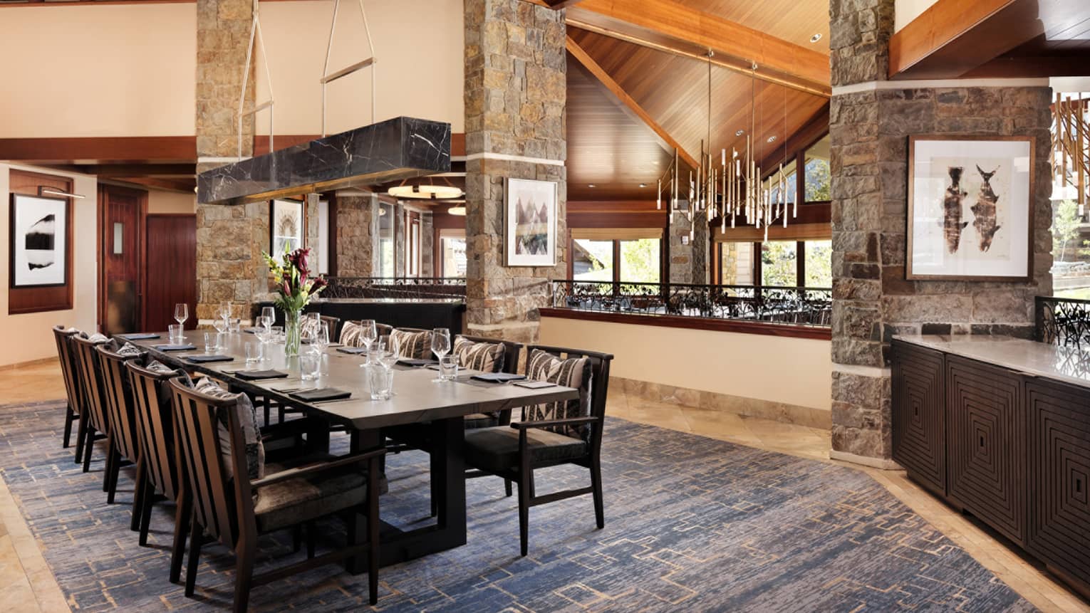 Elegant restaurant dining table with fresh-cut flowers and ten seats on the upper level of Westbank Grill