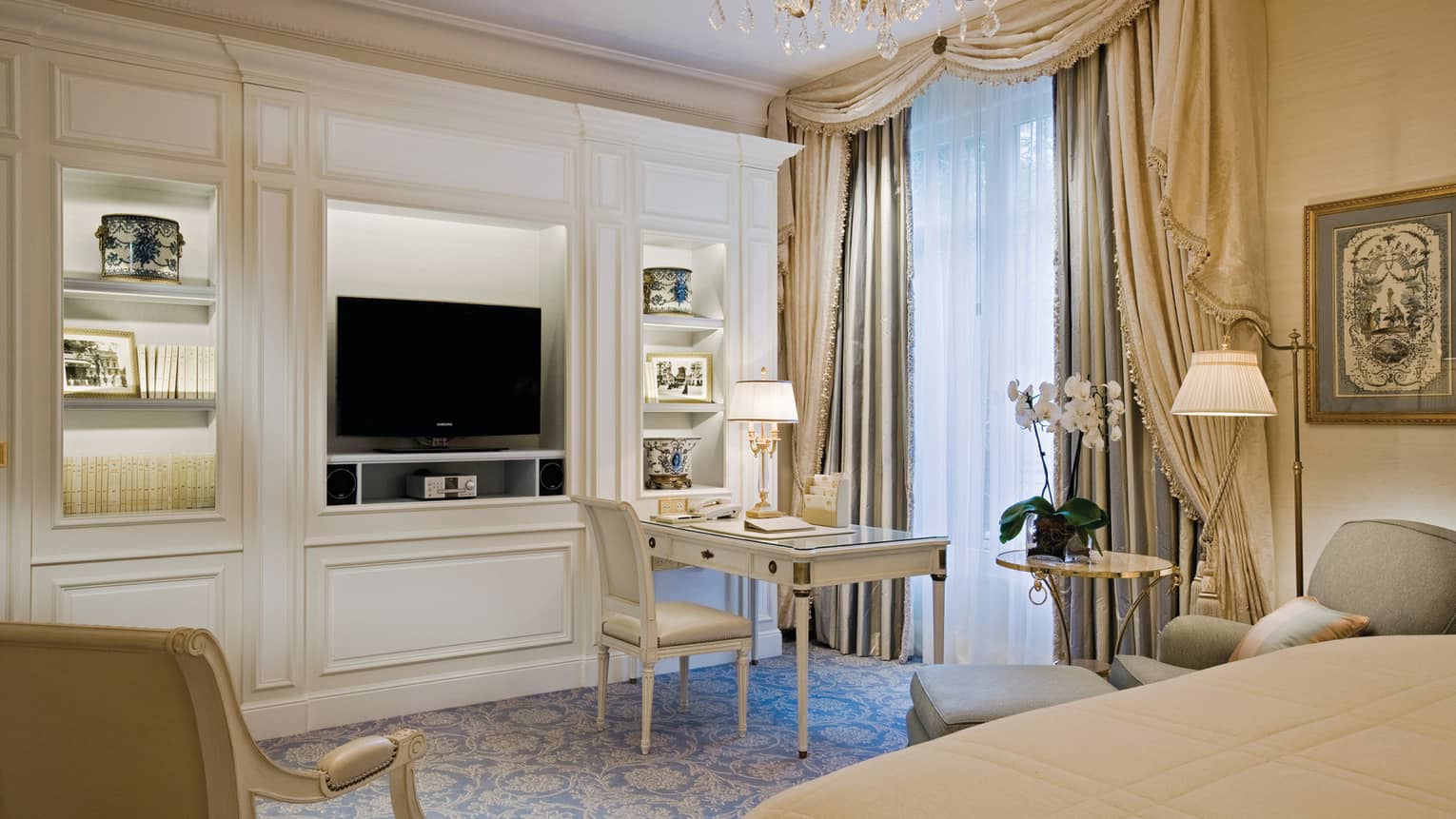 An ornately decorated room with a large built-in entertainment stand, desk and seating area