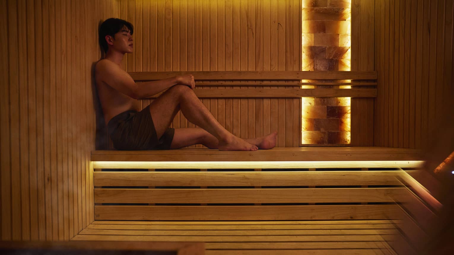 A man lounges in a sauna