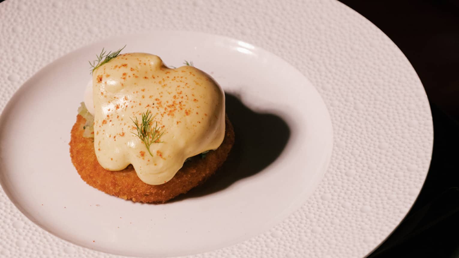 Crab cake benedict with fried crab cake, caper relish, poached eggs, hollandaise sauce and dill