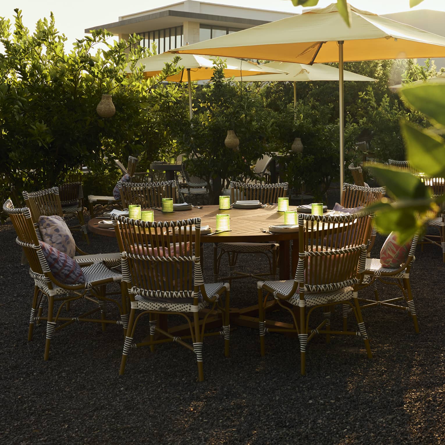 Round outdoor table with rattan chairs in garden setting