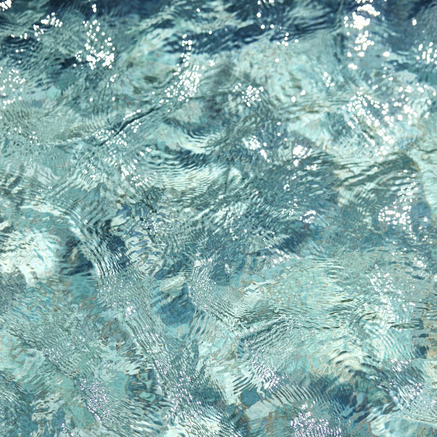 Ripples and wavelets on the surface of turquoise blue water.