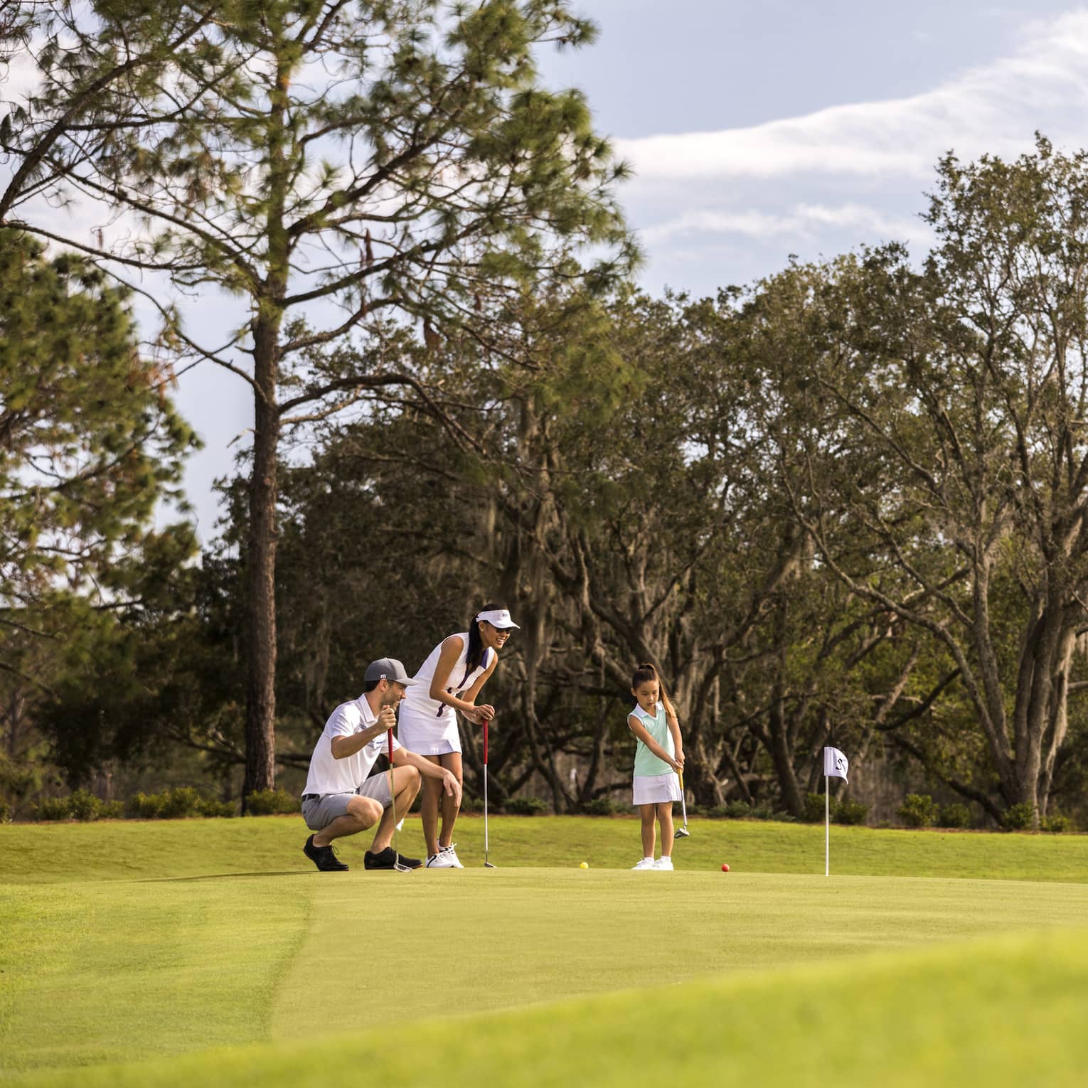 A family playing golf on a golf course
