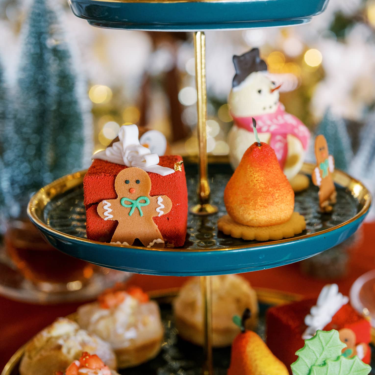 A three-tiered display with a gingerbread cookie and desserts