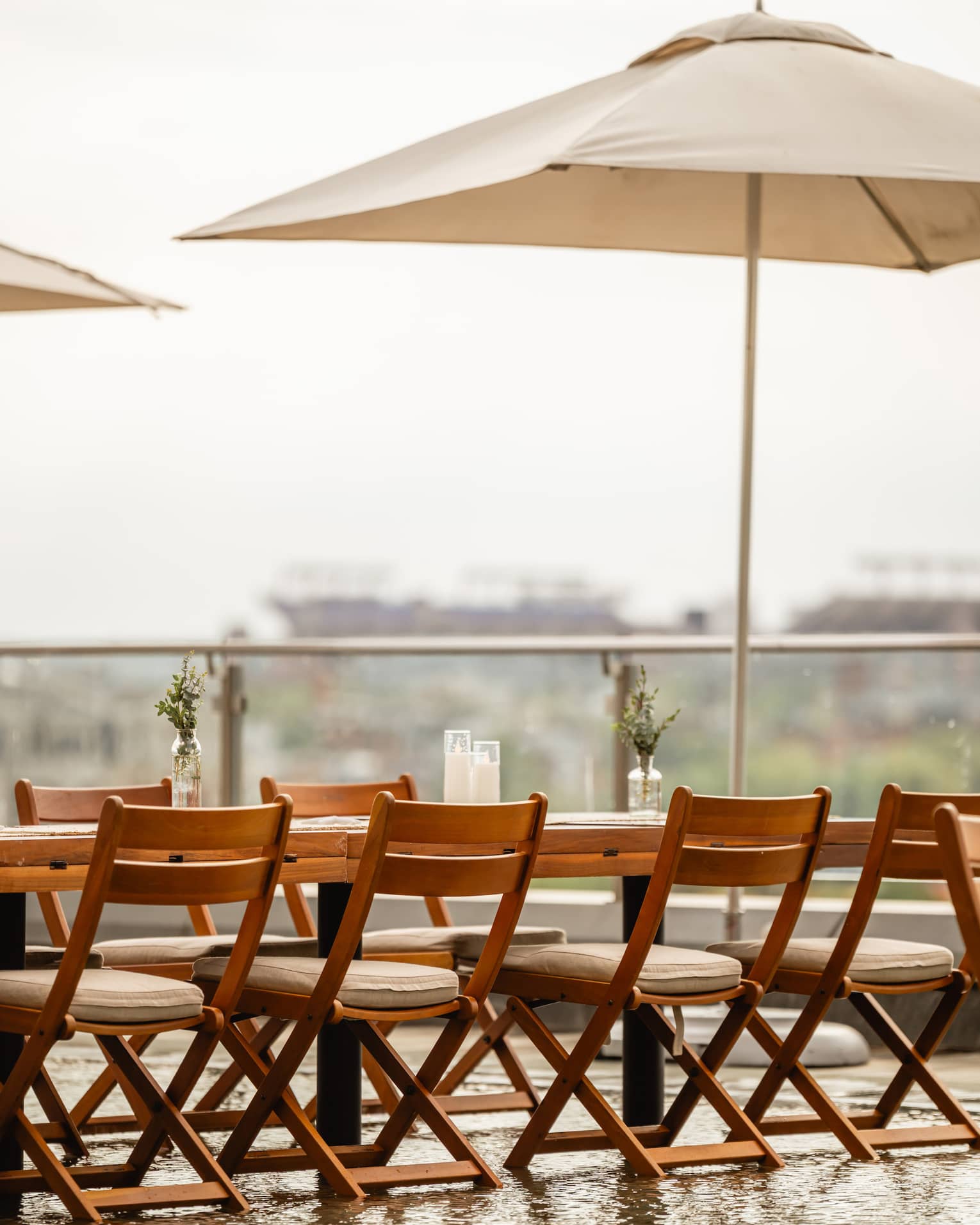 A table and chairs with umbrellas set up outside on a rooftop terrace