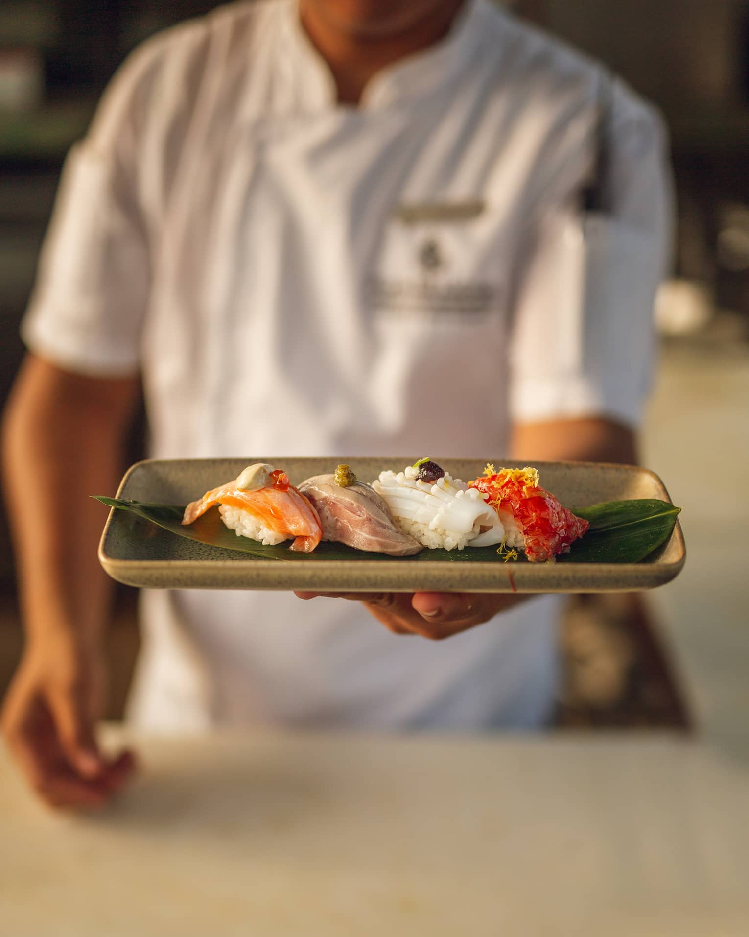 Chef holds a platter of nigiri selection