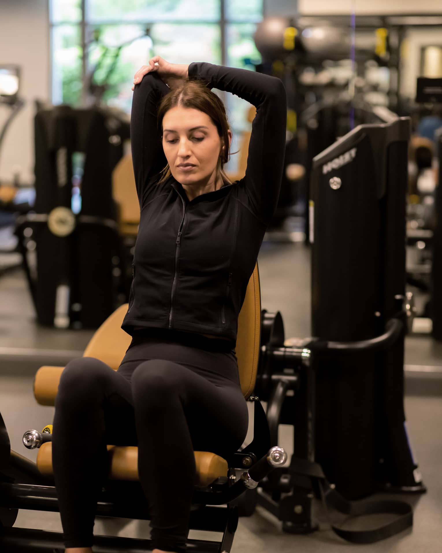 Guest stretching while sitting on an exercise machine.