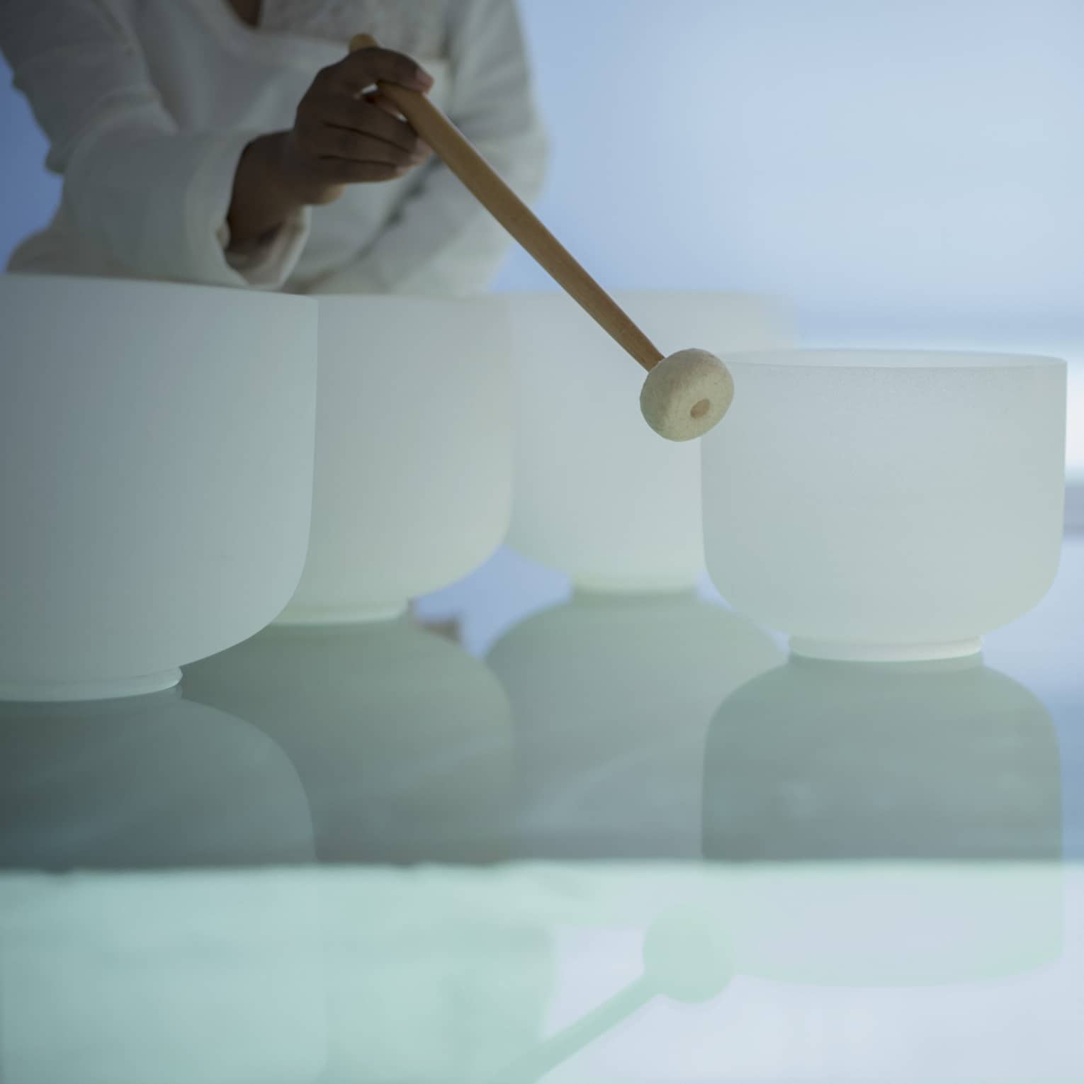 Woman plays singing crystal bowls at the Spa