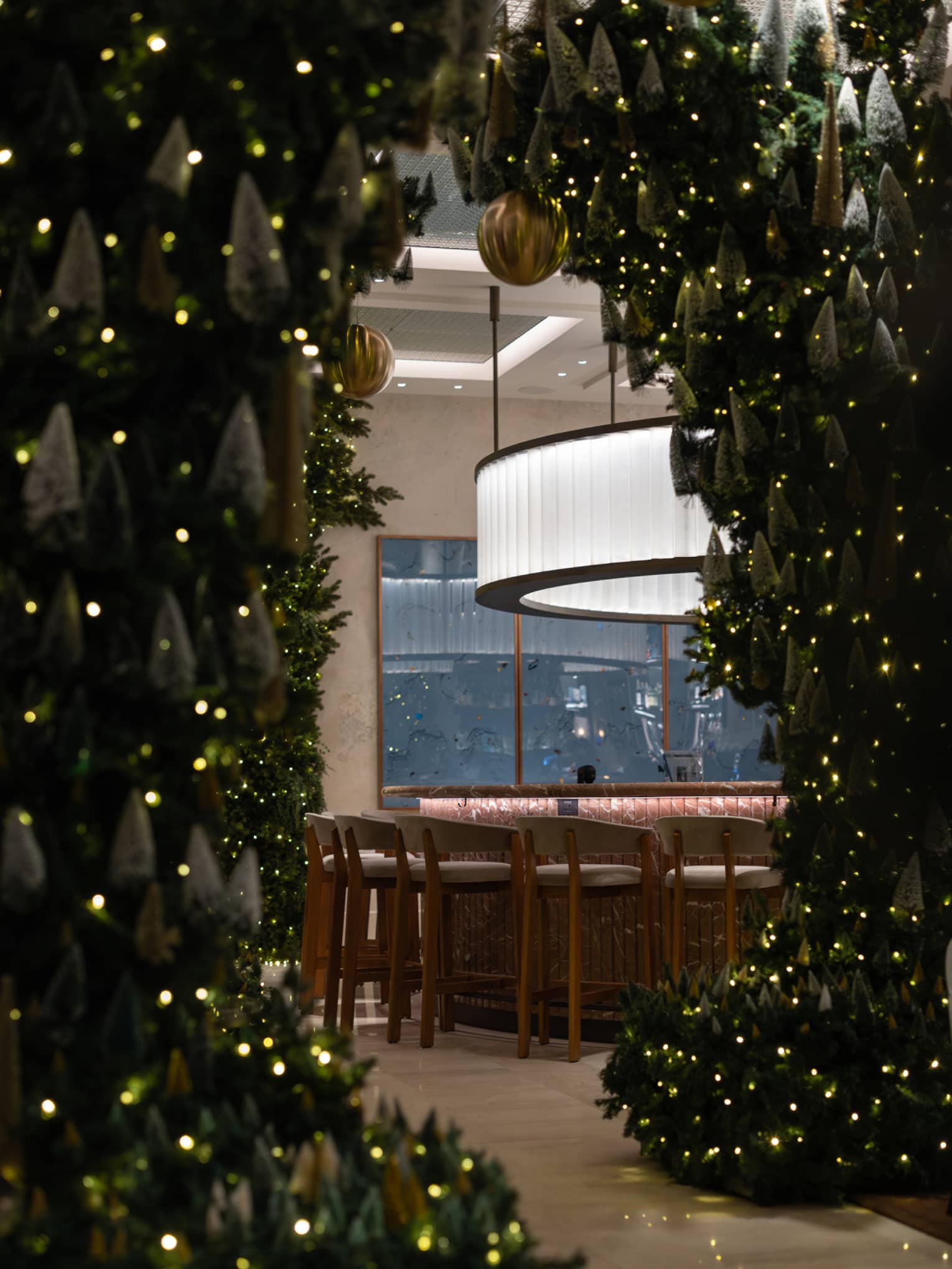 Festive greenery and lights around an entry into an elegant bar space