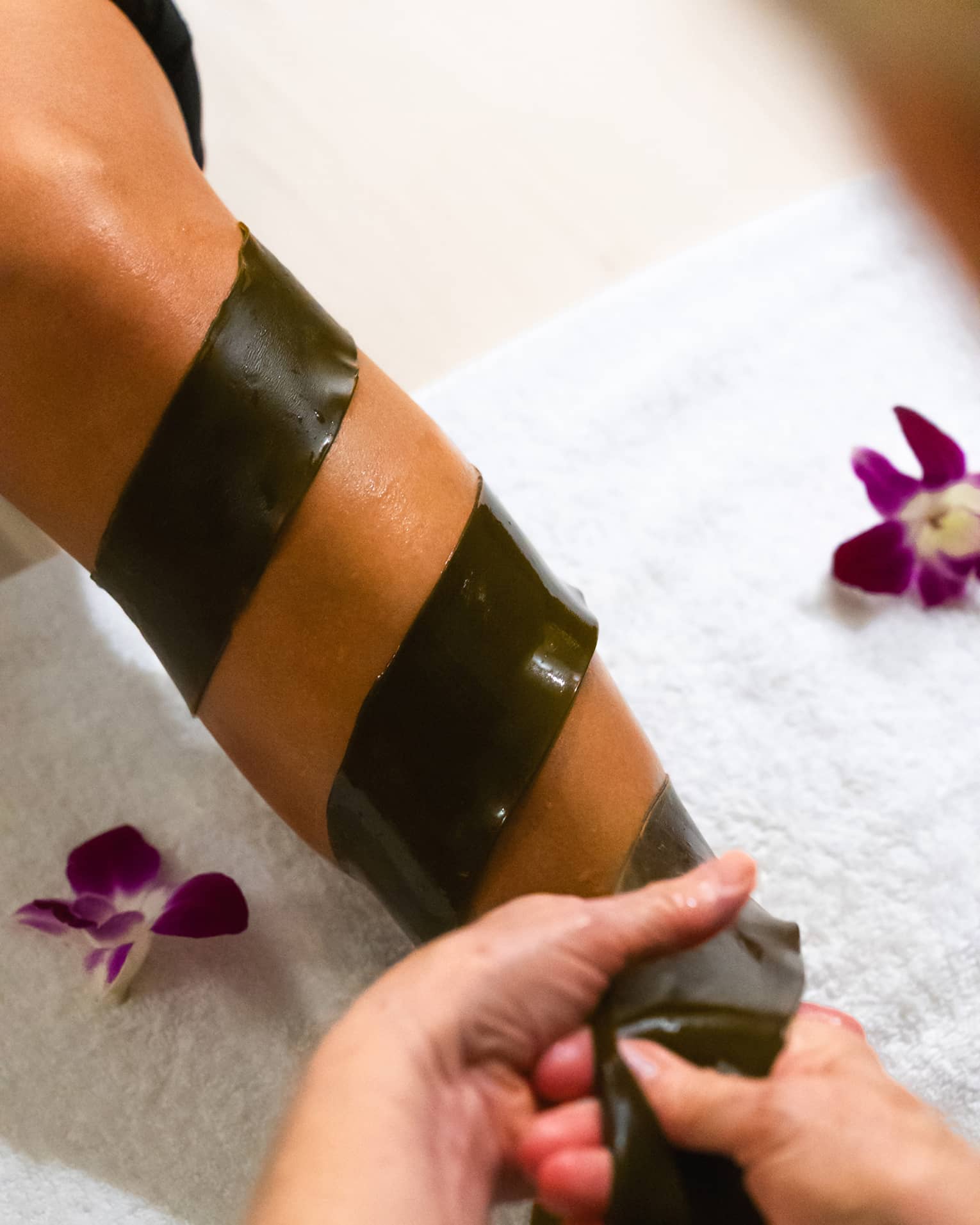A piece of seaweed is being wrapped around someone's arm