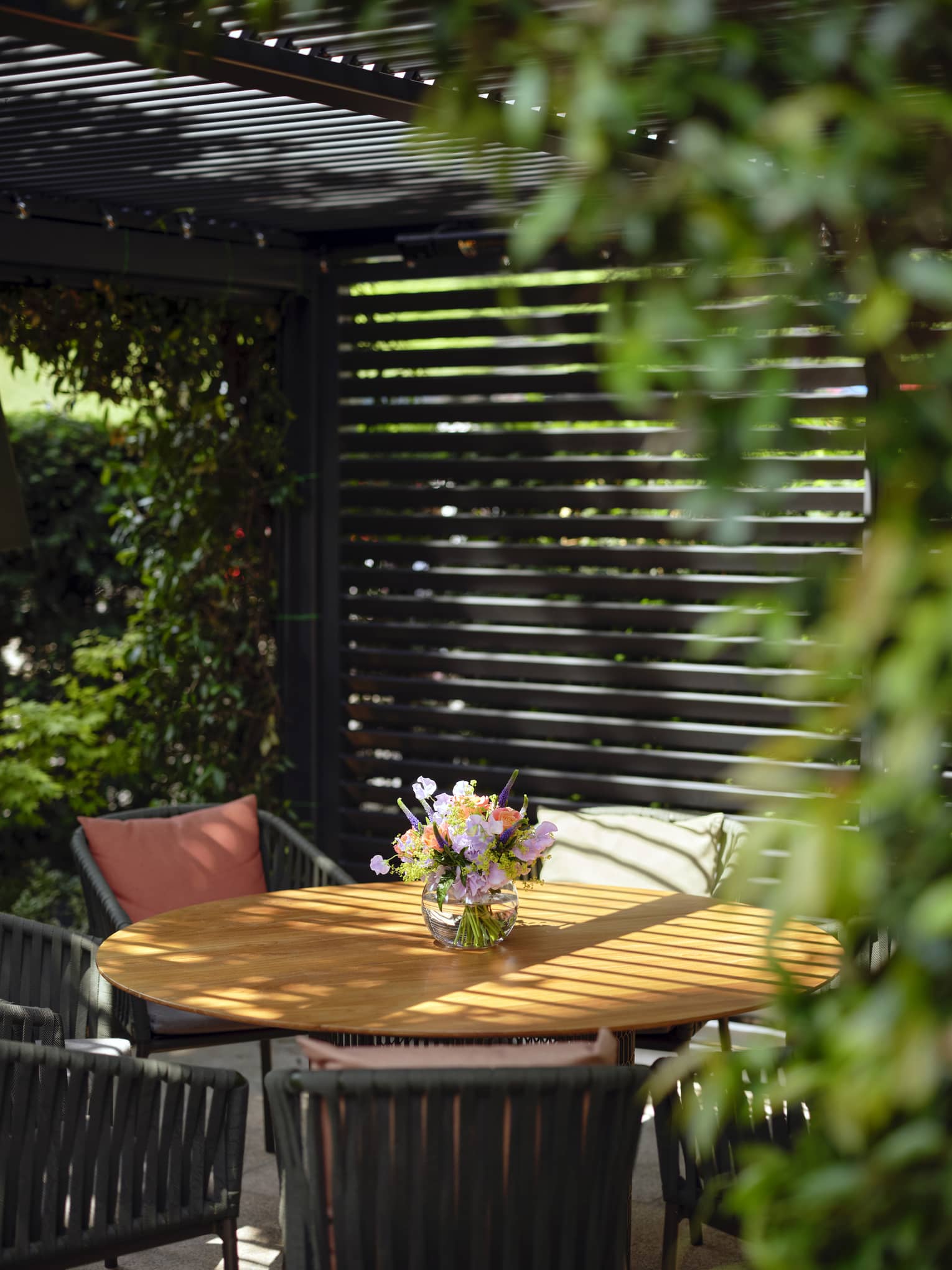 Terrace dining seating under shade of black pergola