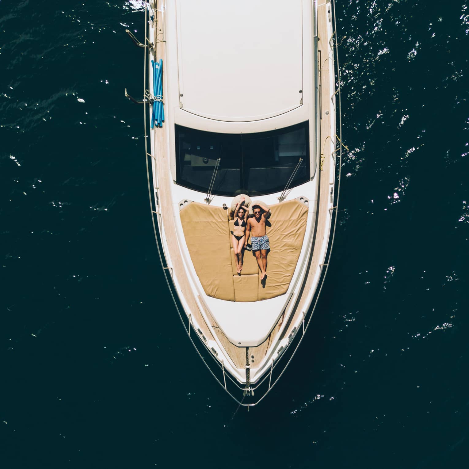 Aerial view of couple relaxing on the front of a large boat