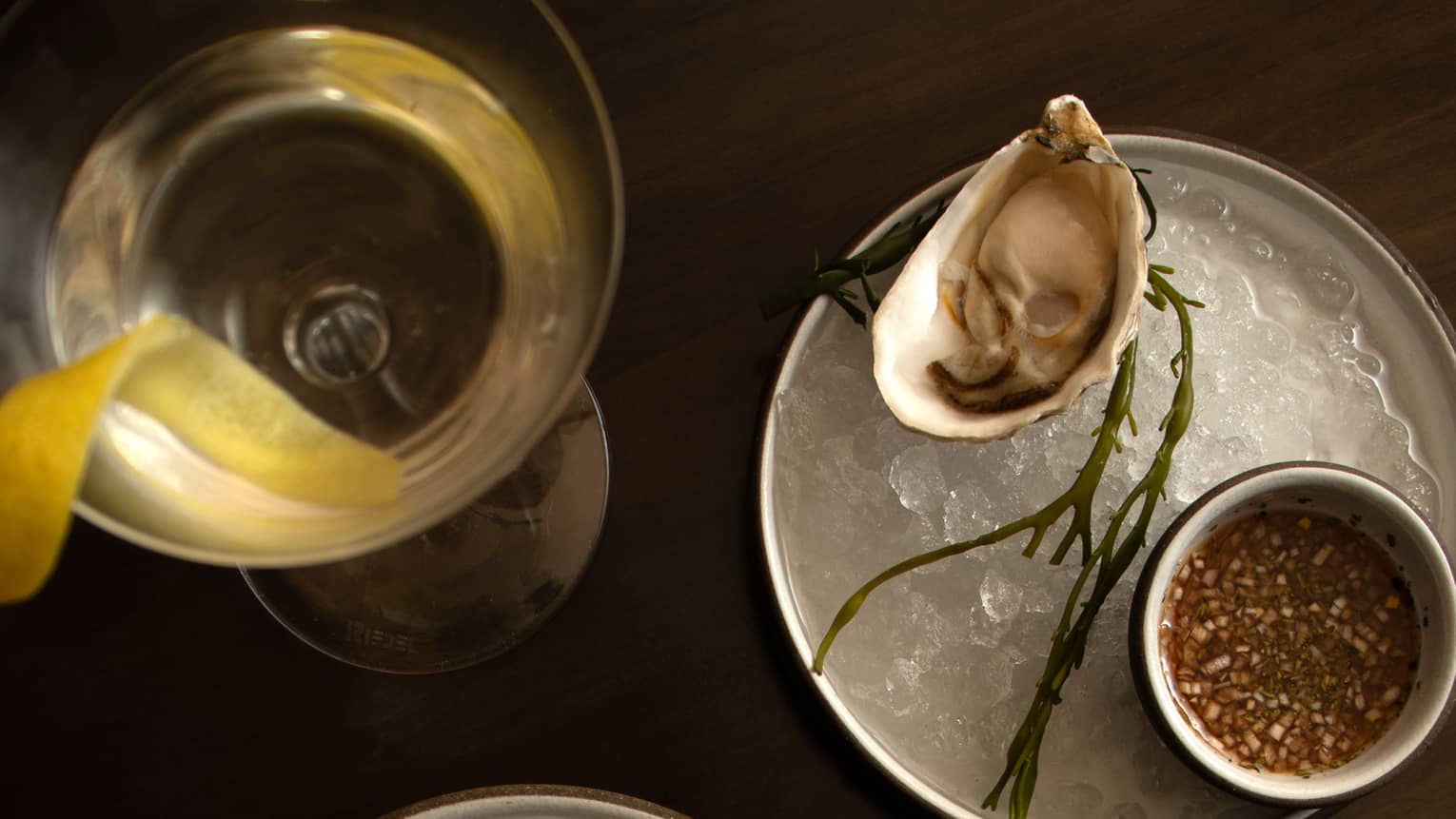 Oysters in a bowl of ice with a martini glass on the side