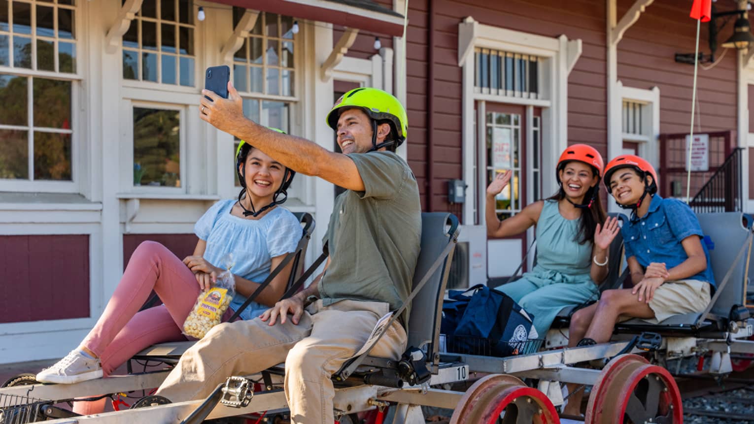 Four guests taking a photo while riding railbikes