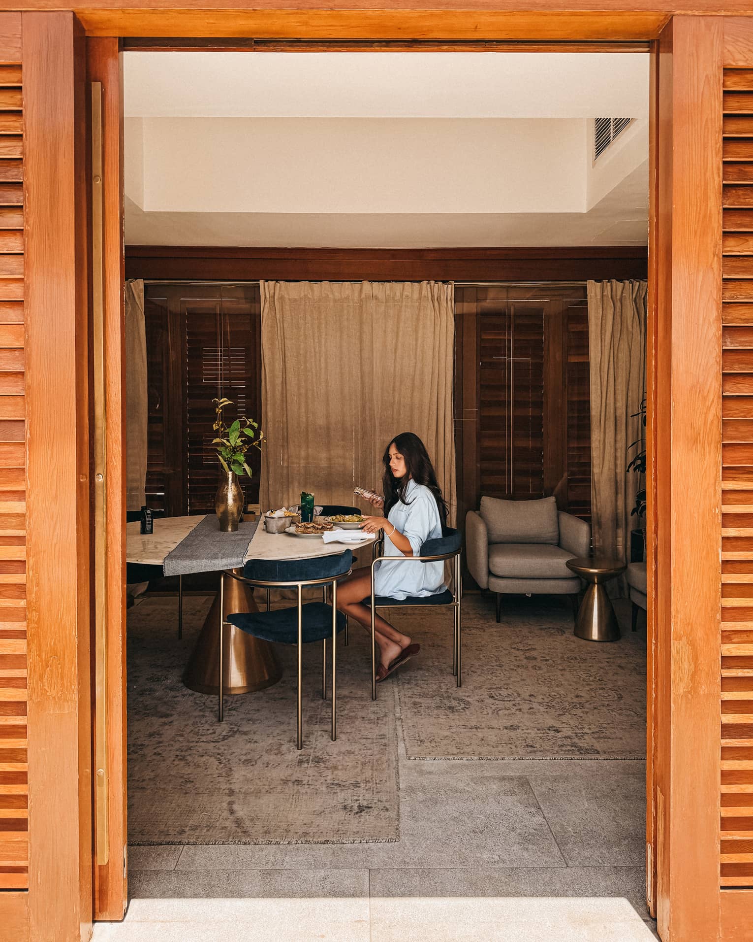 Guest sits inside a cabana at a marble dining table
