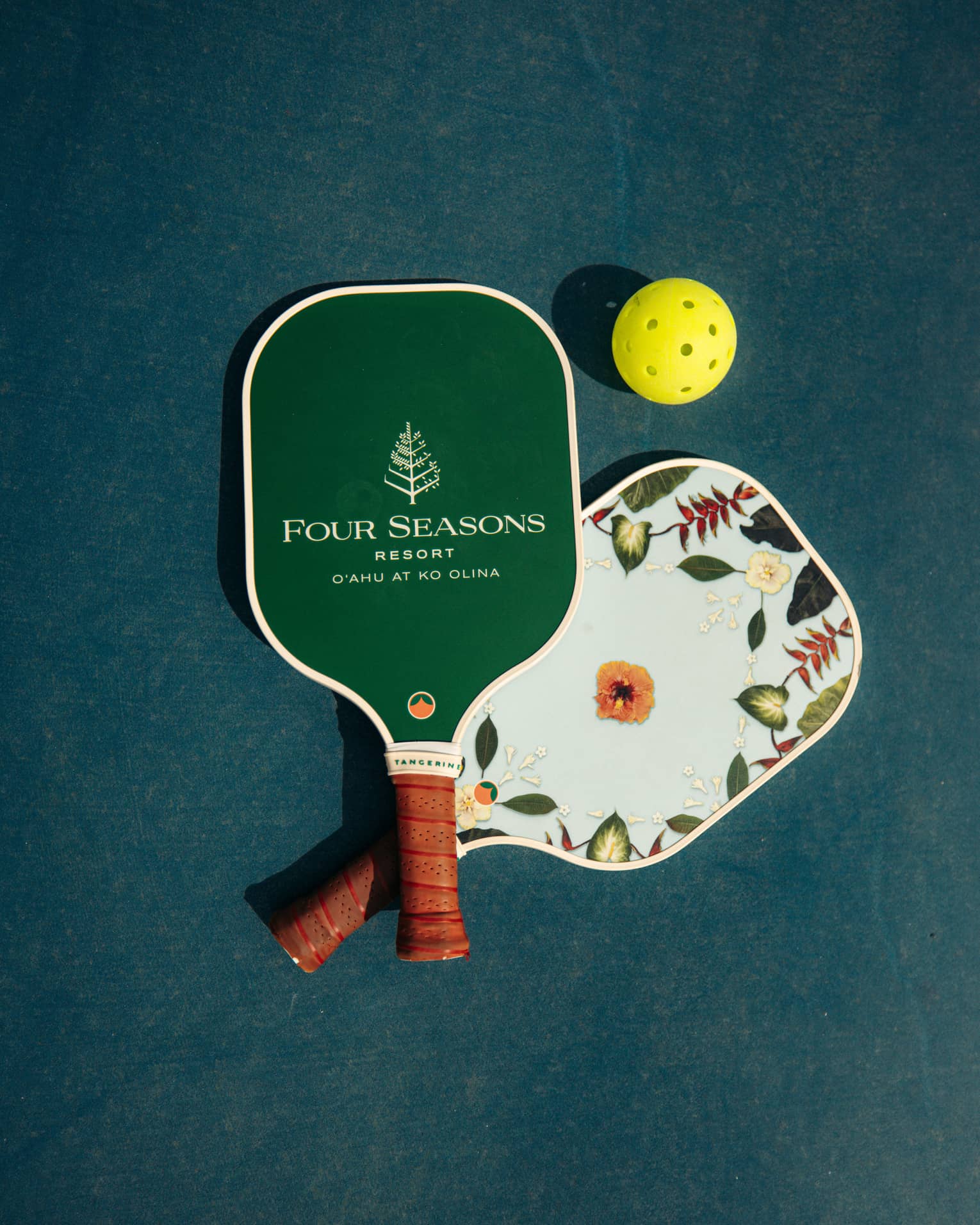 Pickleball paddles with Four Seasons Resort logo, and a yellow ball