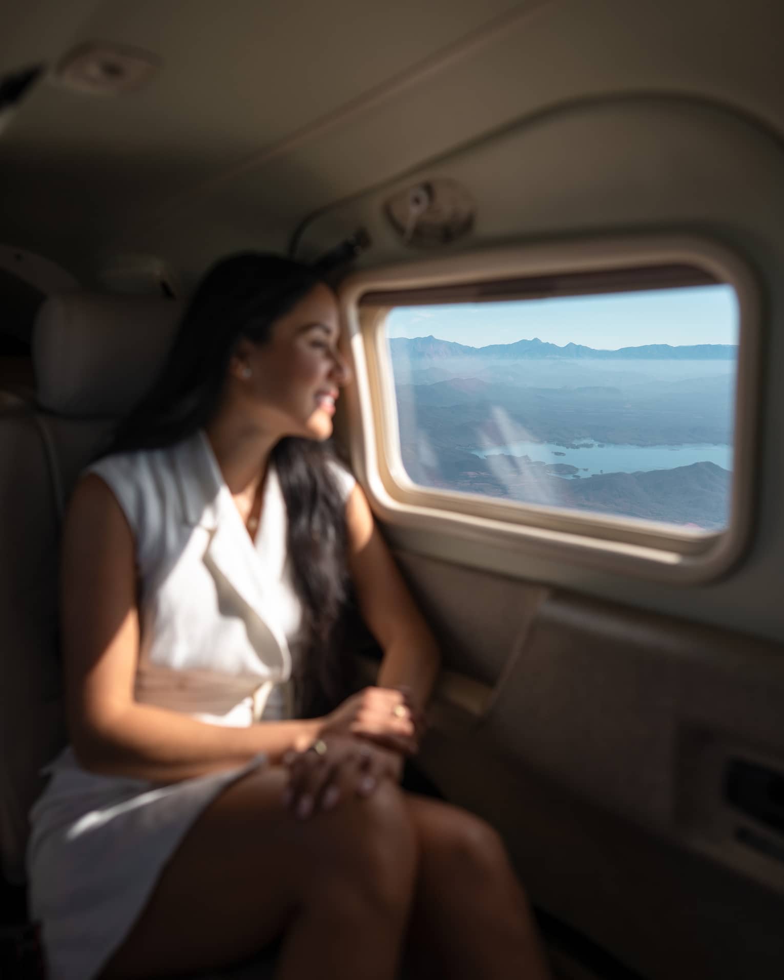 A woman looks out a plane window