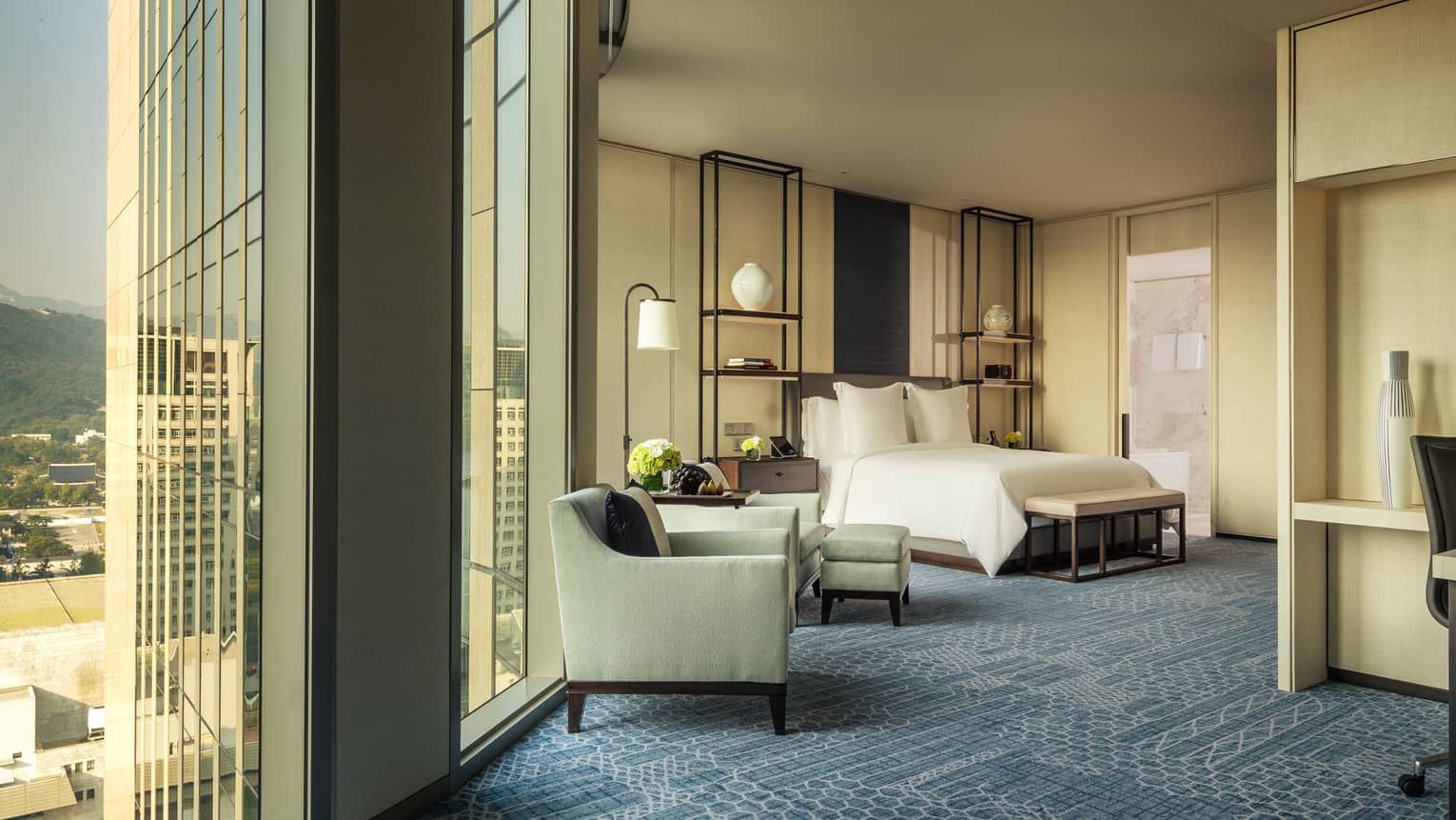 Studio Suite armchairs by tall windows, hotel bed, alcove with work desk
