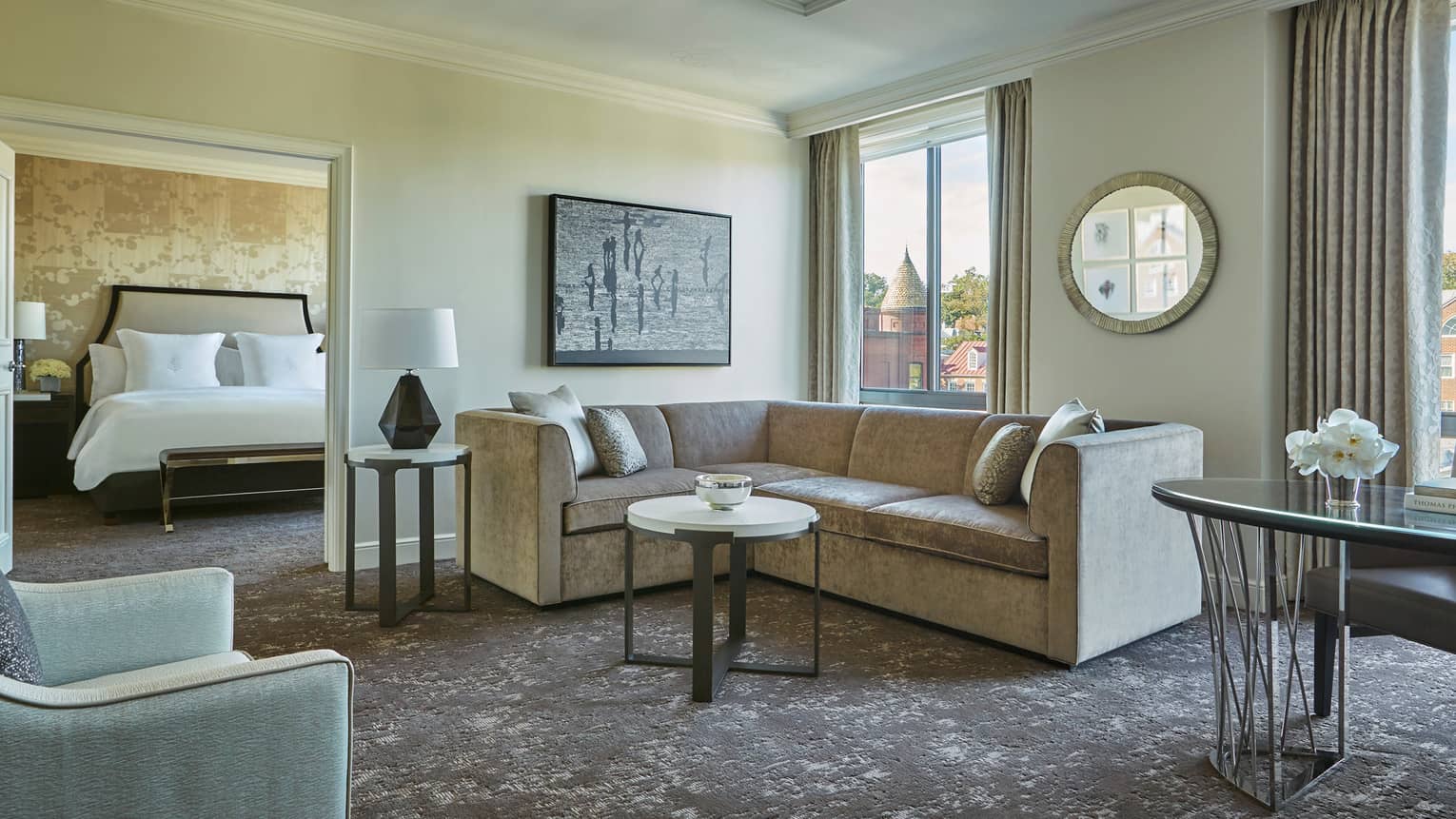 Georgetown One-Bedroom Suite L-shaped grey sofa between door to bedroom, large picture windows, work desk