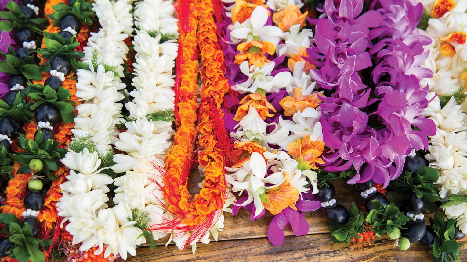 Rows of colourful flower lei necklaces 