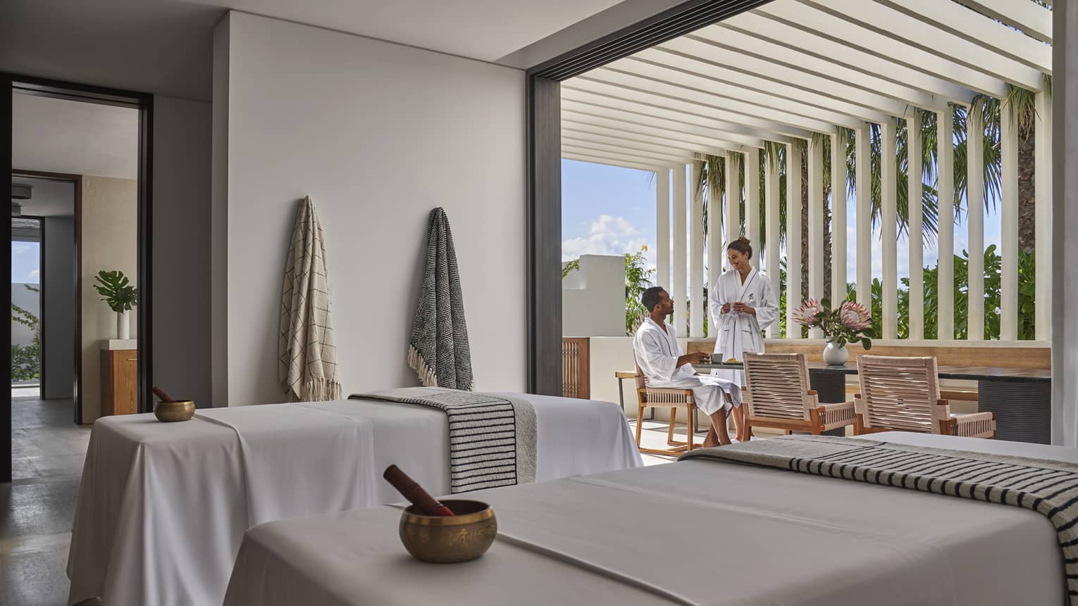 A man and woman relaxing in a spa room while talking.