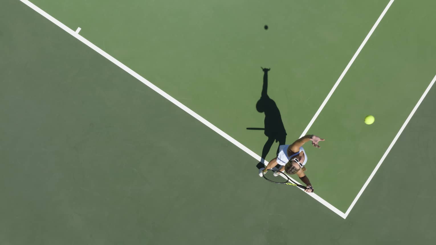 Aerial view of a tennis player mid serve