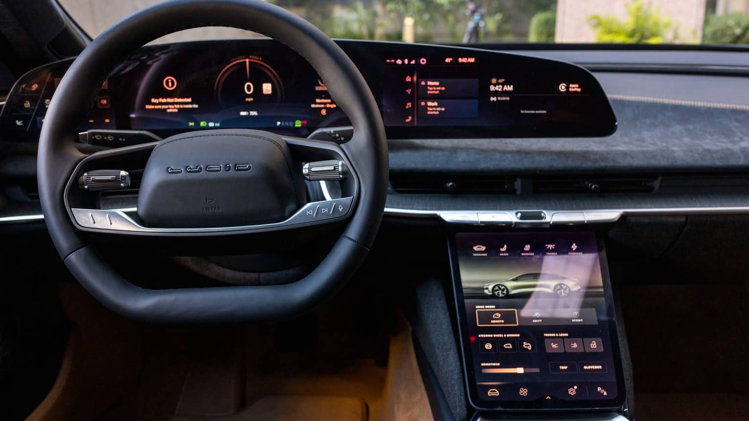 A car dashboard, window and steering wheel