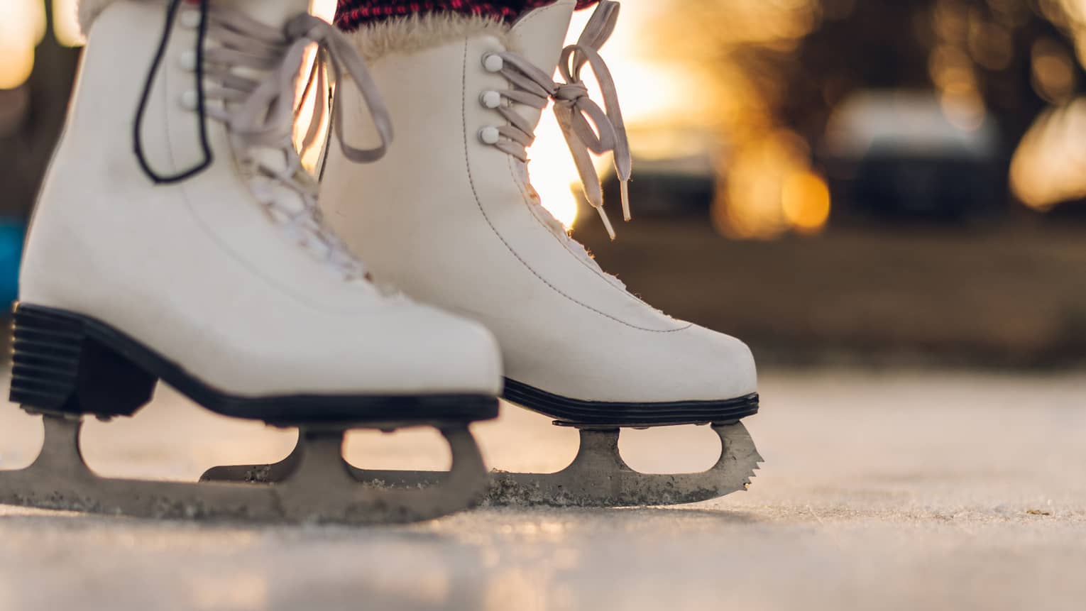 A pair of white ice skating boots.