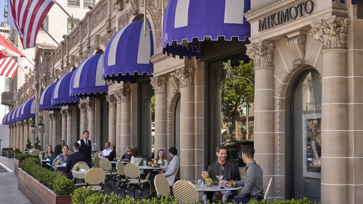 A patio eating area outside of a stone building.
