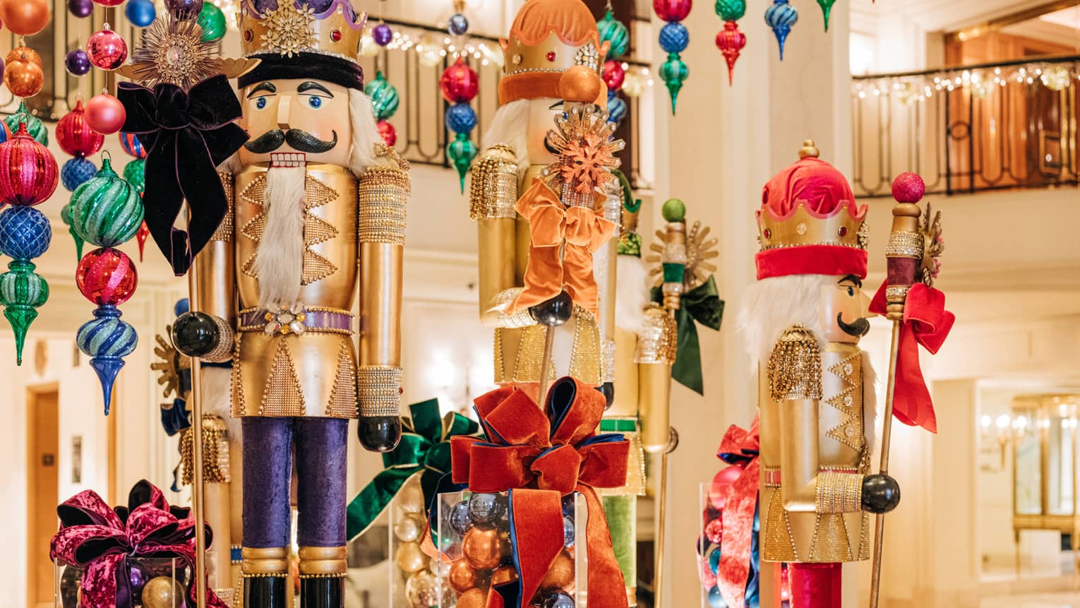 Hotel lobby decorated for the holidays with large gold nutcracker statues and colourful ornaments hangins from the ceiling