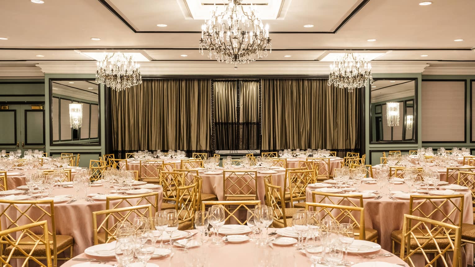 A function room with round tables set with plates and glasses