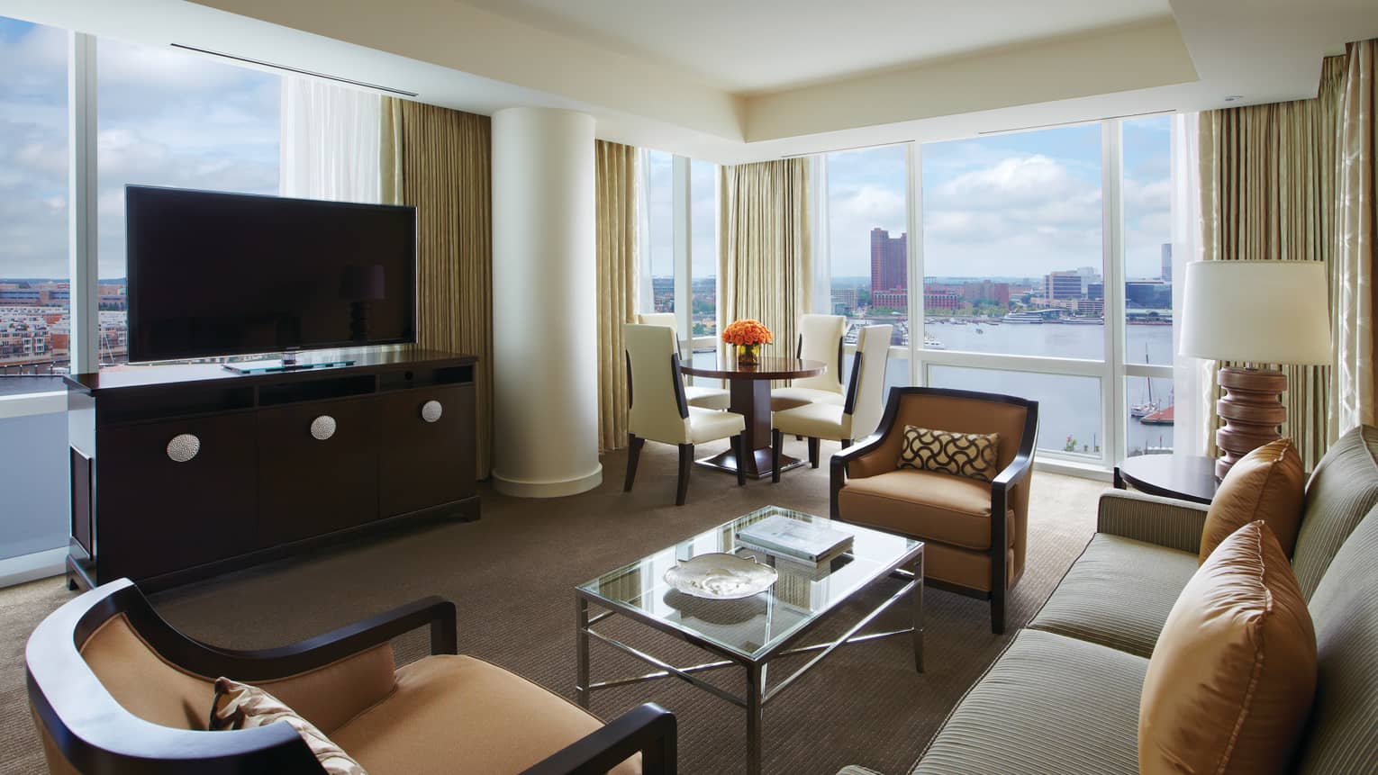 Harbour Suite loveseat, armchairs, dresser and TV in front of window overlooking water