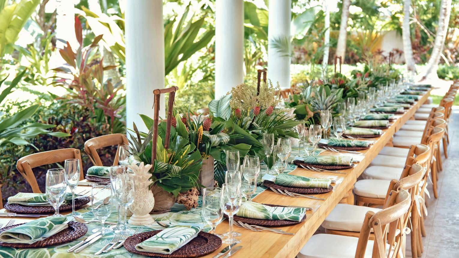 Versailles outdoor terrace with a set table with a green leafy runner and napkins 