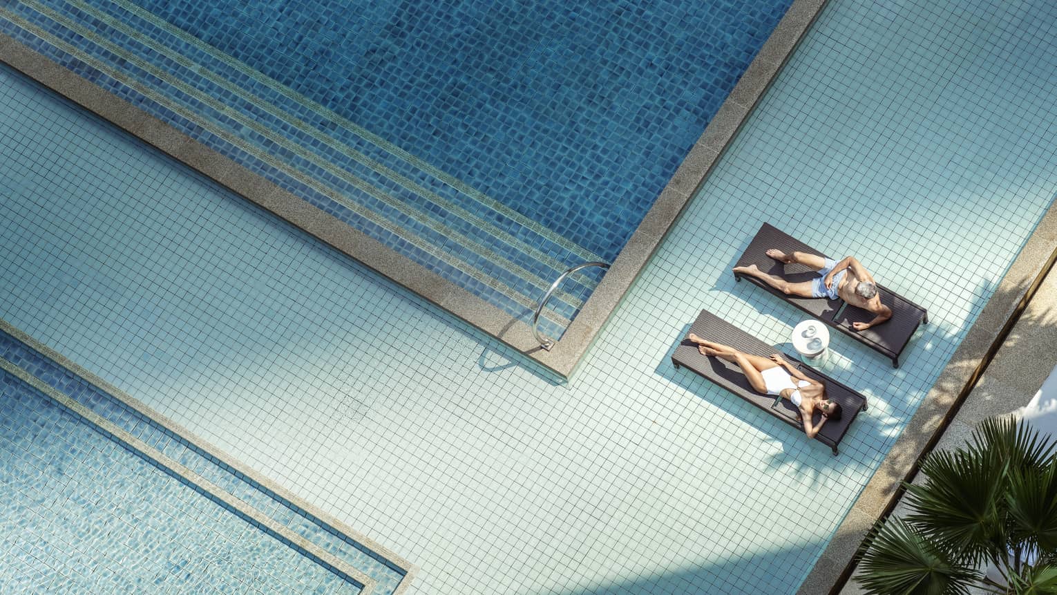 Aerial shot of two women on lounge chairs in pool
