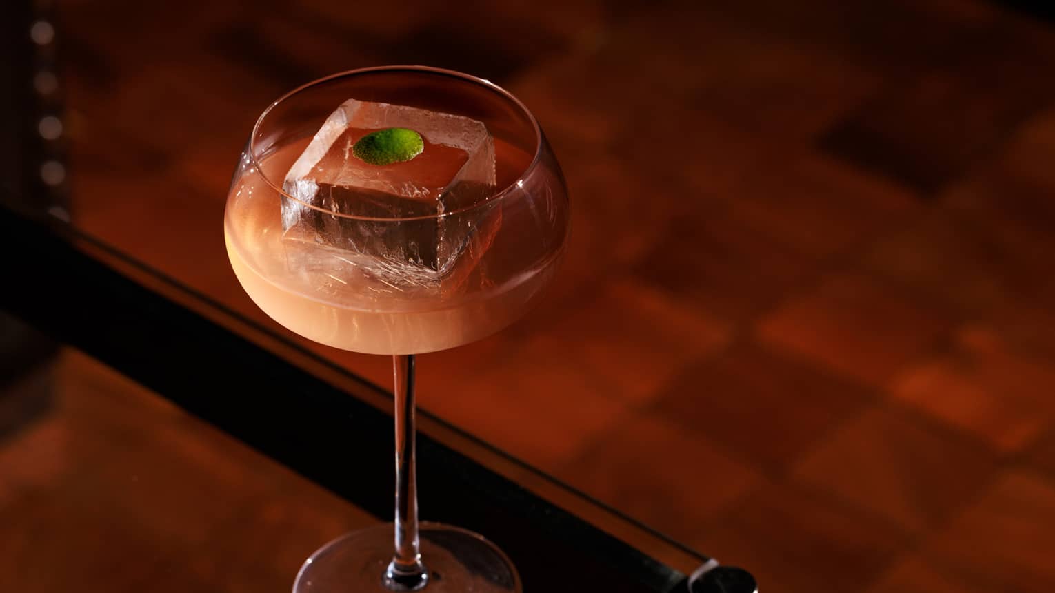 Mezcal cocktail in a couple glass with a single large ice cube