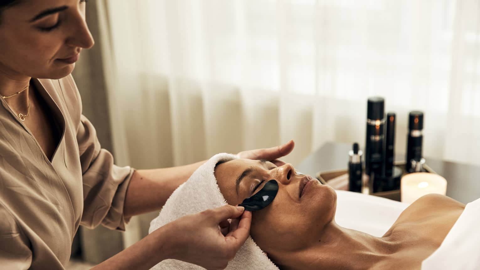 A woman getting a facial treatment in a well lit spa.