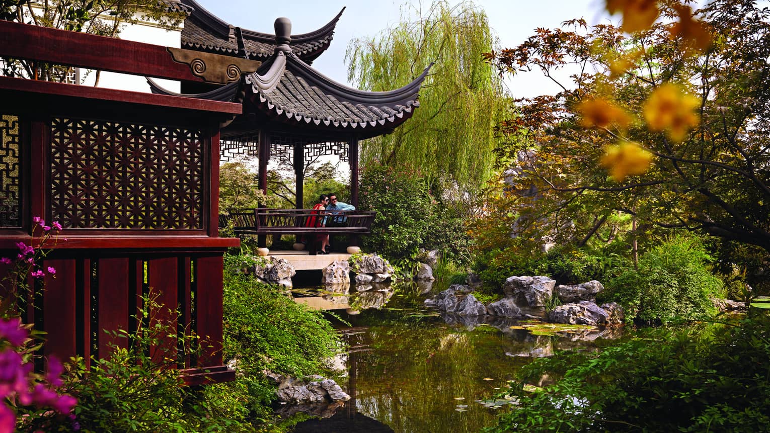 Pavilion building over lagoon and lush gardens