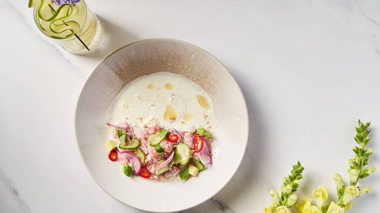 A dish with sliced vegetables and a wine bottle placed beside it