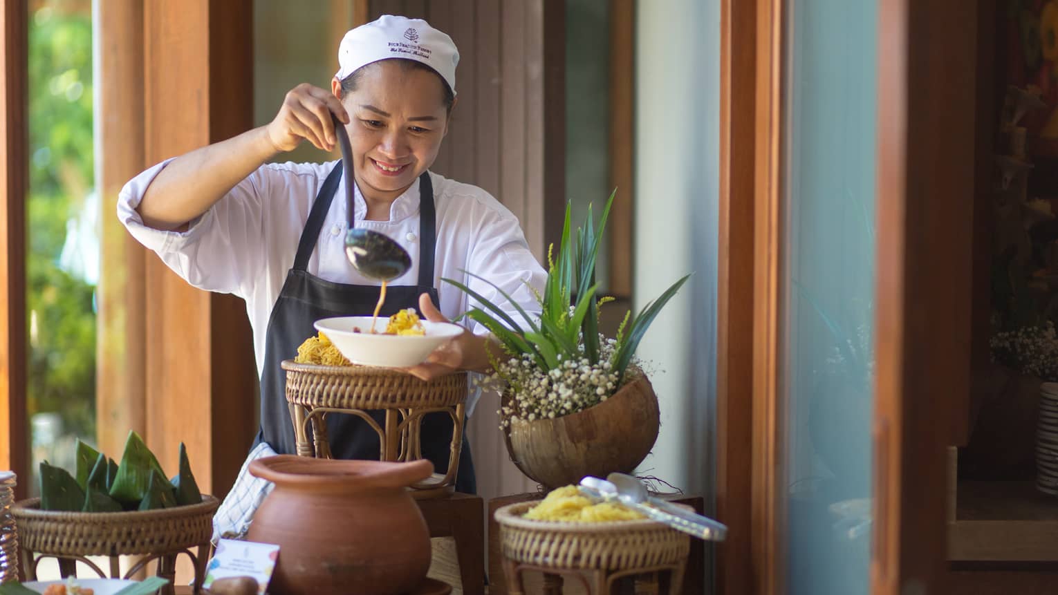 Sunday Brunch at the Khao Soy Station, chef ladles noodle soup into a bowl