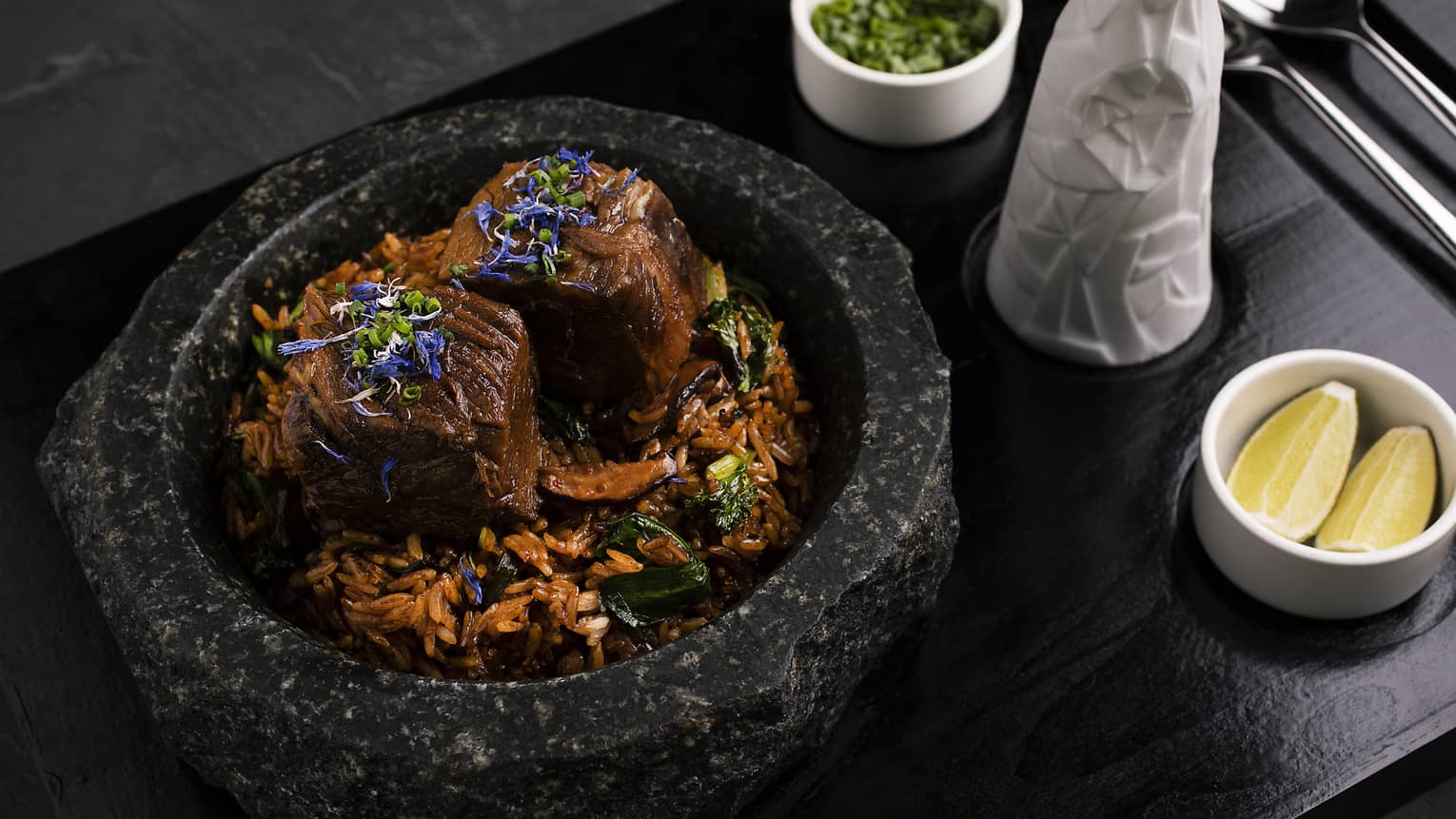 Wagyu ribs, jasmine rice, shiitake mushrooms, Chinese chive, bok choy sprouts, own jus and spring onions served in a black stone pot