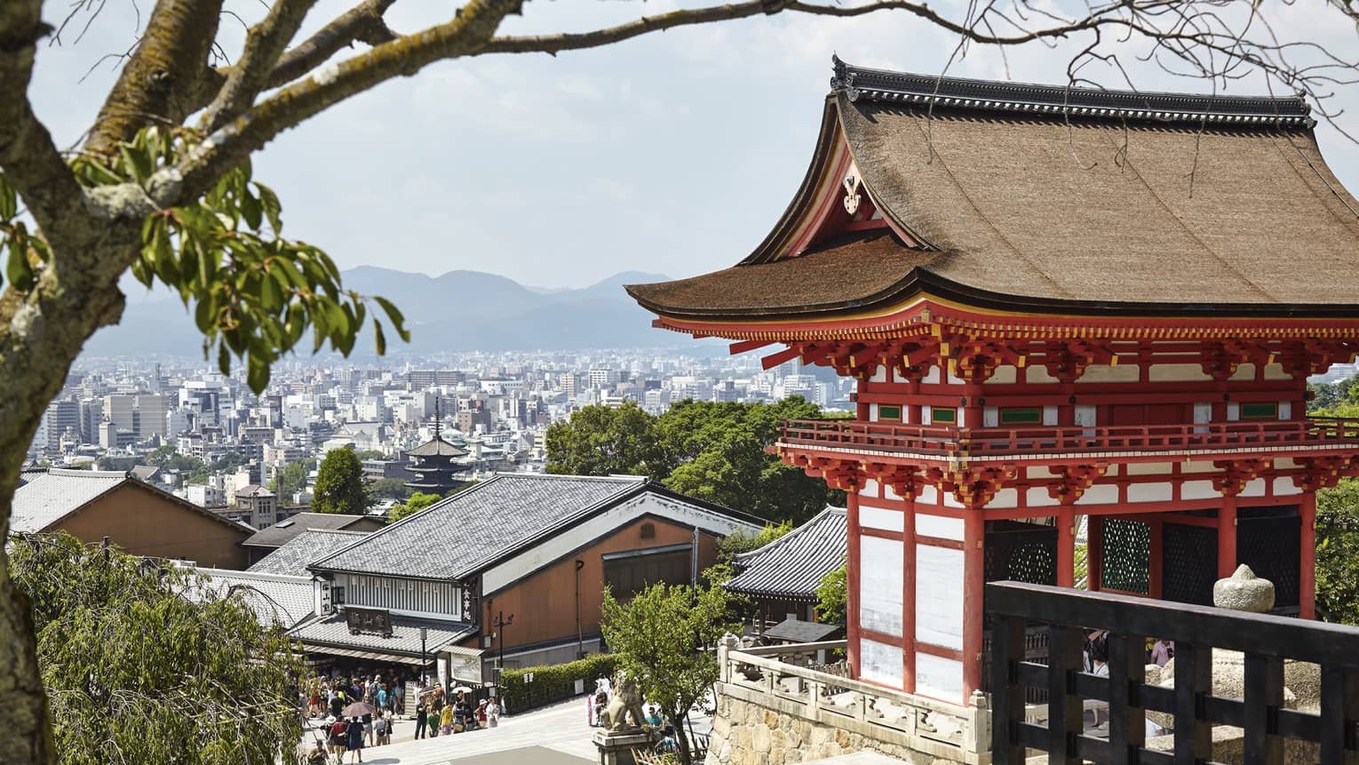 People walk along street under traditional Japanese building, Kyoto city views