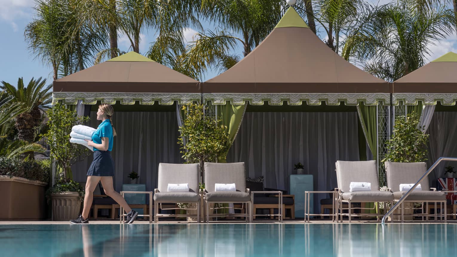 5 Star Hotel Los Angeles Luxury In Four Seasons Hotel Staff Carries Stack Of White Towels Past Cabanas On Outdoor Swimming Pool Deck