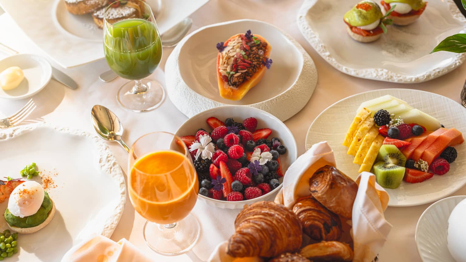 An array of brunch food items and beverages set out on a dining table