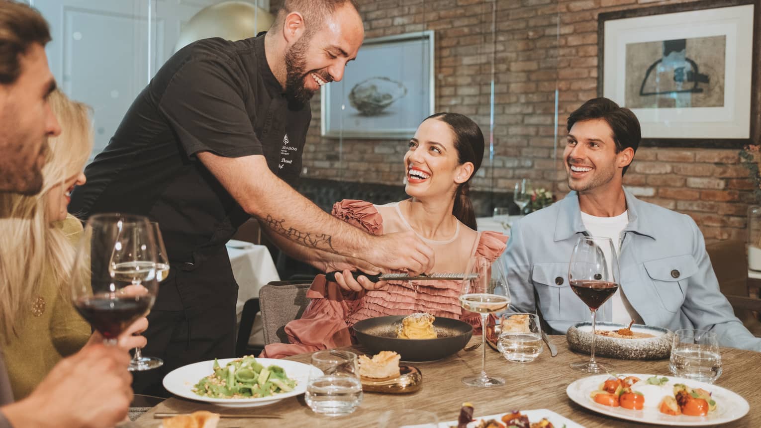 A group sitting around a round table eating food.