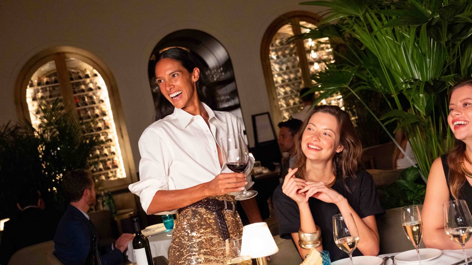 A group of people gathered at a dining table and smiling at one another